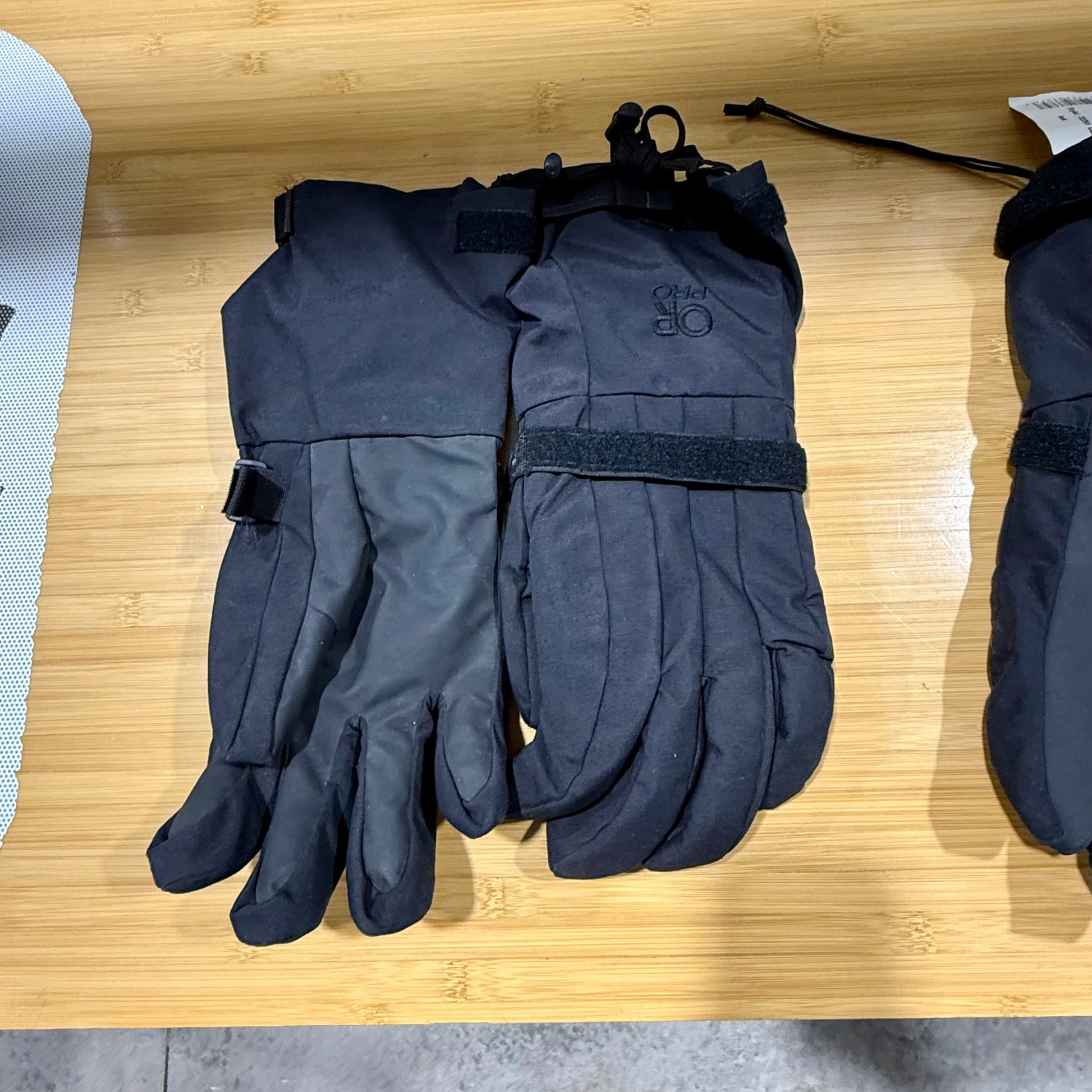 Pair of black gloves on a wooden surface