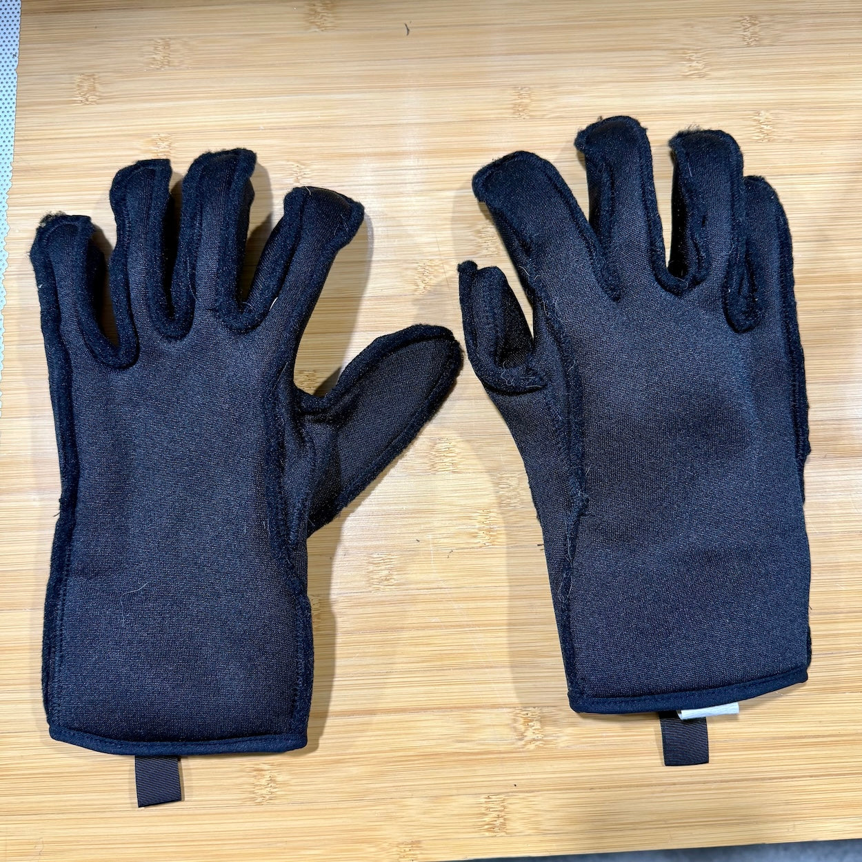 Pair of dark blue gloves on a wooden surface