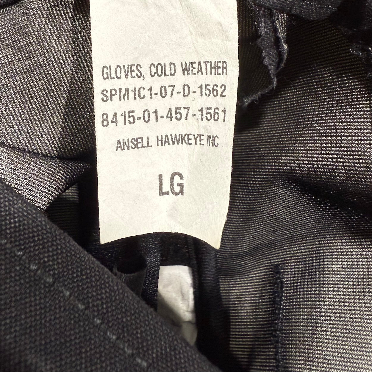 Close-up of a label on a pair of cold weather gloves with product details.